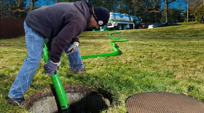 Service technician performing residential septic pumping and drainage maintenance in Anchorage, AK